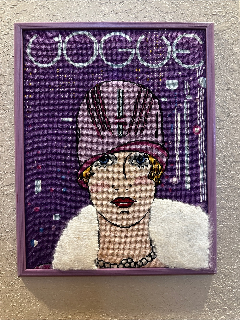 Framed needlepoint artwork depicting vintage 1927 Art Deco Vogue magazine cover